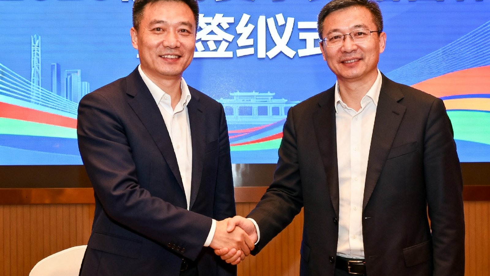 新球体育与杭州马拉松组委会在签约仪式上握手合影，背景大屏显示2025杭马赛事数据合作字样